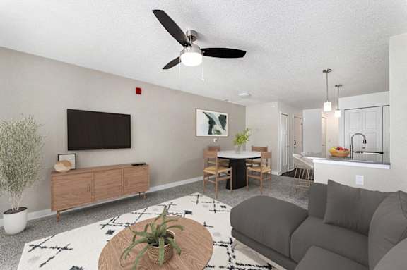 A living room with a grey couch, a wooden coffee table, and a ceiling fan at Eagle Ridge Apartment Homes, Traverse City, MI 49685