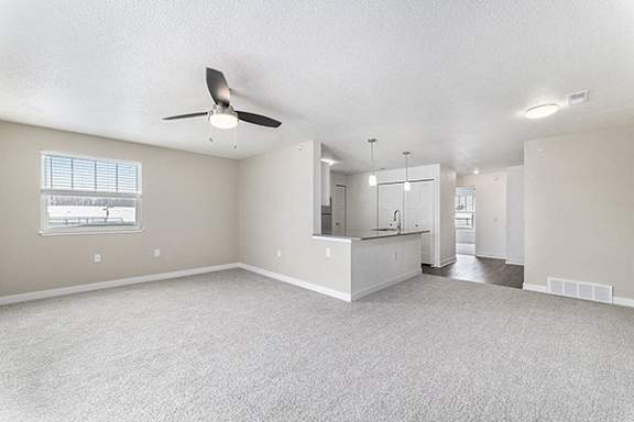 An enlarged living room with a ceiling fan and an extra window at Eagle Ridge Apartment Homes, Traverse City, MI
