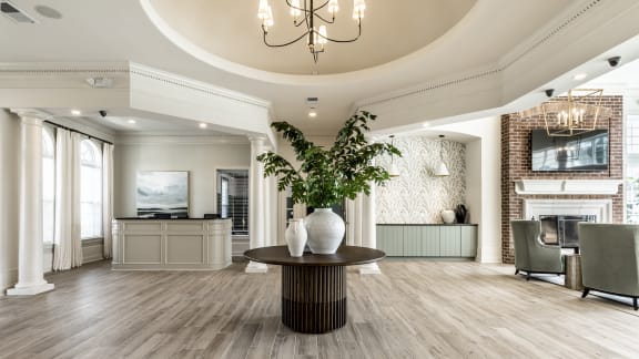 clubhouse/leasing center with a coffee bar fireplace and a round table at Alexandria of Carmel Apartments, Carmel, Indiana