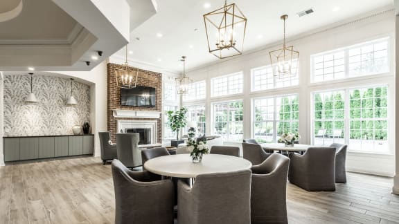 Clubhouse lounge with large windows seating and a fireplace  at Alexandria of Carmel Apartments, Carmel, IN