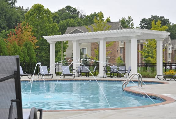 a swimming pool with a pergola and patio furniture  at LakePointe Apartments, Batavia, OH