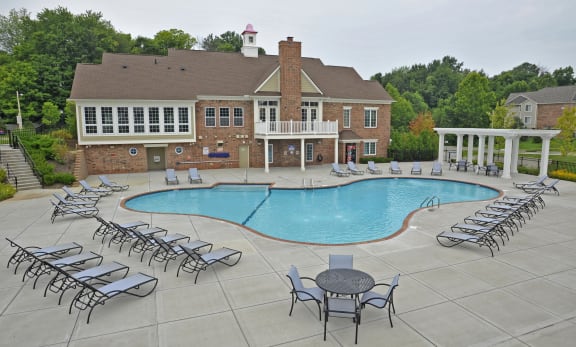 a swimming pool with chaise lounge chairs and a building in the background  at LakePointe Apartments, Ohio, 45103