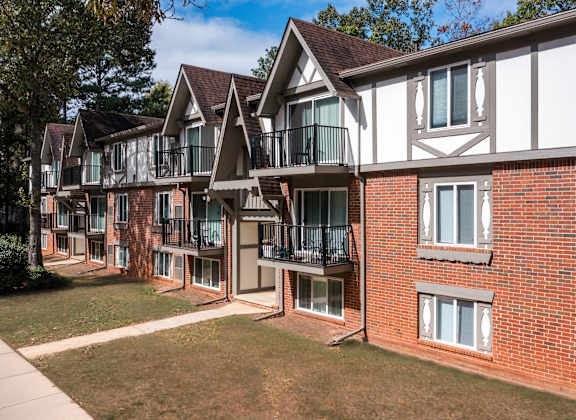 A row of red brick houses with white trim and balconies at Laurel Woods Apartments, South Carolina, 29607