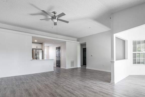 an empty living room and kitchen with a ceiling fan at Latitudes Apartments, Indianapolis, 46237