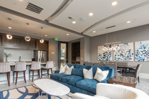 event suite with a blue couch and a table and chairs and kitchen in Carmel, 46032