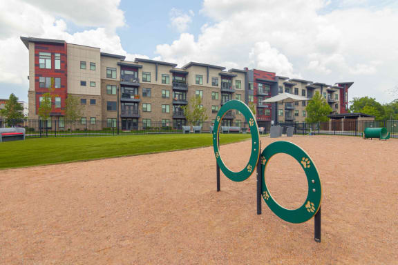 a pet park with agility equipment in front of Avant Apartments, Carmel, IN