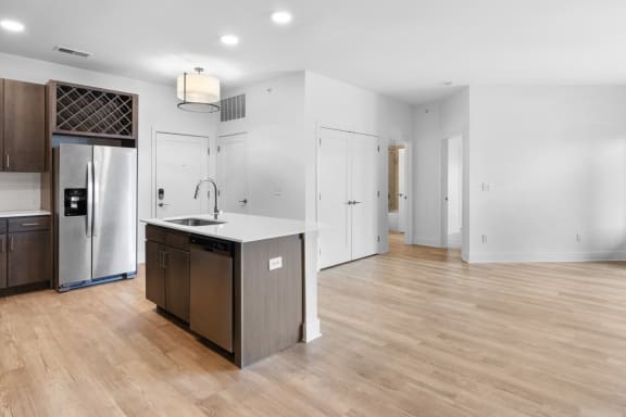 a renovated kitchen with a large island and a stainless steel refrigerator at Avant & Avant II, Carmel, IN, 46032