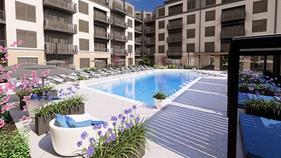 Swimming pool surrounded by apartment buildings with flowers at Icon on Main Apartments, Carmel, 46032