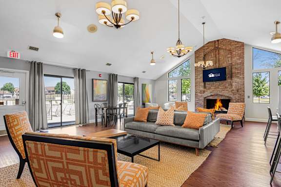 A living room with a grey couch and a fireplace at Bay Pointe Apartments, Lafayette