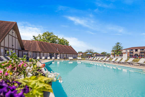 A large swimming pool with lounge chairs and a building in the background at Bay Pointe Apartments, Lafayette, 47909