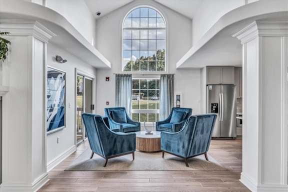 a living room with two blue chairs and a large window  at The Vinings Apartments in Richmond, VA 23234