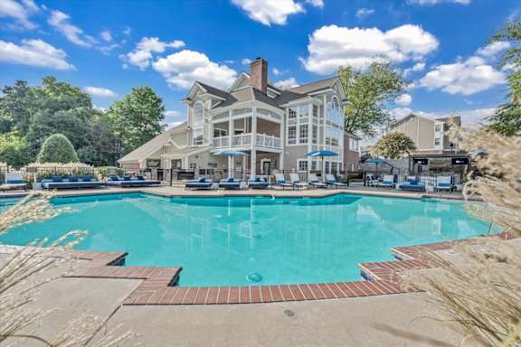 a large swimming pool with a house in the background at The Vinings Apartments in Richmond, VA 23234