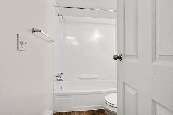 White tub shower combo with chrome hardware at Fairlane Apartments, Springfield, MI