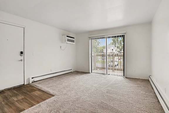 Empty living room with sliding door to patio at Fairlane Apartments, Springfield, MI