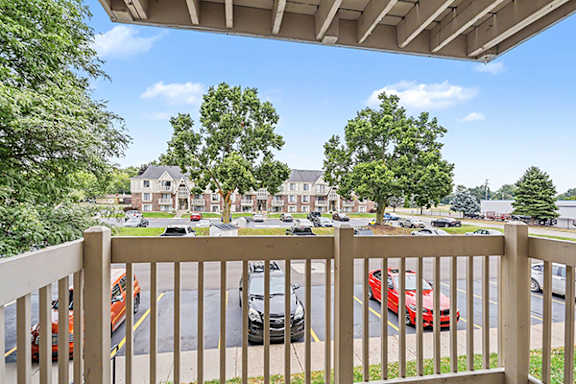 Covered balcony overlooking parking area and landscaping at Fairlane Apartments, Springfield, Michigan