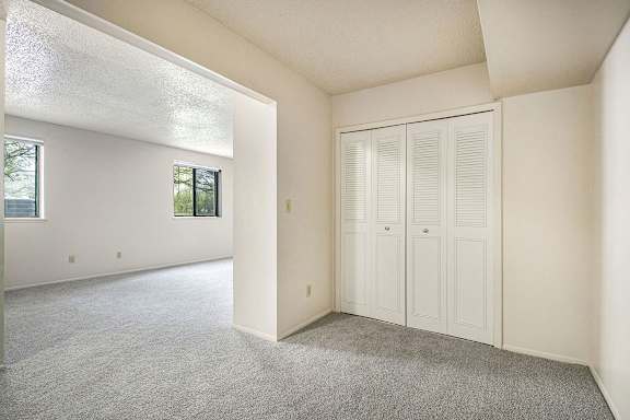 A sleeping area with white walls and a grey carpet at Old Farm Apartments, Elkhart, 46517