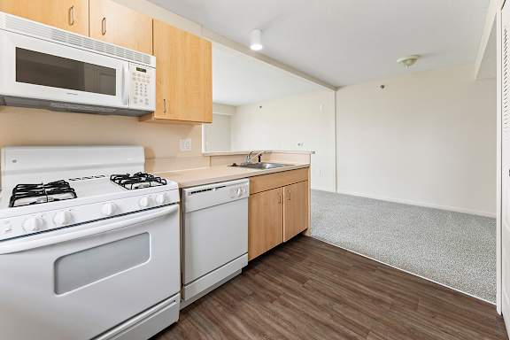 A kitchen with a white stove and microwave above it at Fieldstream Apartment Homes in IA 50023