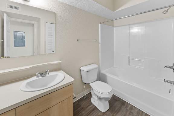 A bathroom with a toilet, sink, and bathtub at Fieldstream Apartment Homes, Iowa