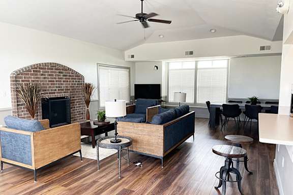 A living room with a brick fireplace and a couch at Fieldstream Apartment Homes in Ankeny, IA