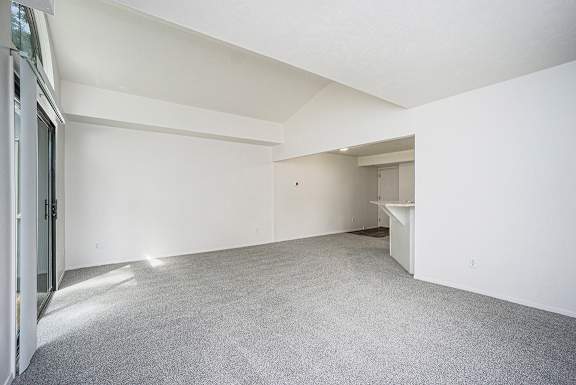 A large, end style living room with white walls and a grey carpet at Foxwood and The Hermitage in Portage, MI