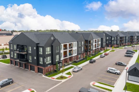 an aerial view of a row of apartment buildings in a parking lot  at Uptown Square Apartments, Troy, 48083