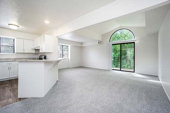 An enlarged, empty living room with a cathedral ceiling at Glenn Valley Apartments, Battle Creek, MI, 49015