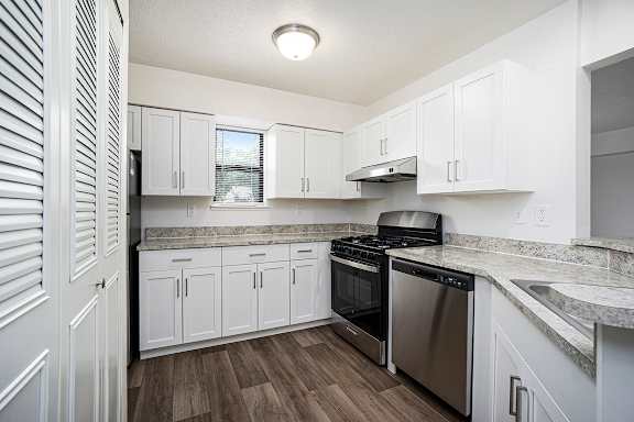 A kitchen with a window and white cabinets at Glenn Valley Apartments, Battle Creek, MI, 49015