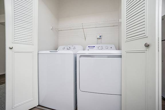 A full-size washer and dryer in a small laundry room at Glenn Valley Apartments, Battle Creek, MI, 49015