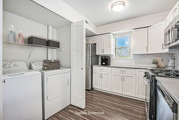 A white kitchen with hard surface floors and a washer and dryer at Green Ridge Apartments, Grand Rapids, 49544