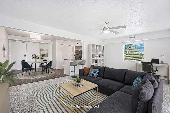 An enlarged living room with a grey couch and a coffee table at Green Ridge Apartments, Grand Rapids, 49544