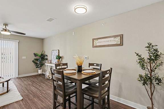 A dining room with a table set for two and a hard-surface floor at The Grove Apartment Homes, Nebraska