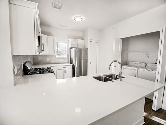 A kitchen with white countertops and a window at The Grove Apartment Homes in Lincoln, NE
