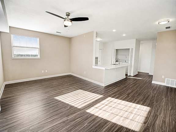 An end style living room with a ceiling fan and a window at The Grove Apartment Homes in Lincoln, NE