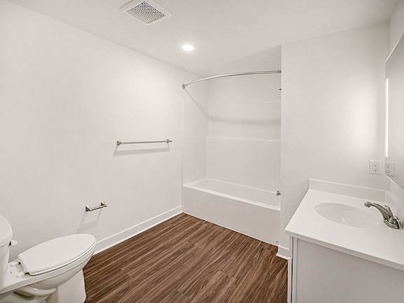 A white bathroom with hard-surface flooring at The Grove Apartment Homes in Lincoln, NE