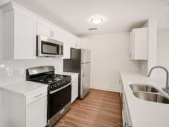 A kitchen with white, shaker-style cabinets and stainless steel appliances at The Grove Apartment Homes in Lincoln, NE