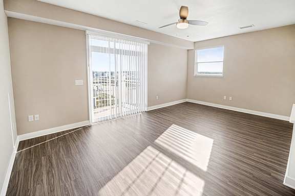 An enlarged living room with a ceiling fan and sliding glass doors at The Grove Apartment Homes, Nebraska, 68512