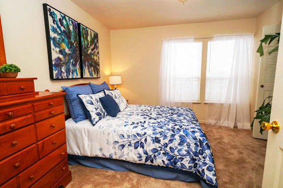 a bedroom with a bed and a dresser at Gull Prairie/Gull Run Apartments and Townhomes, Michigan, 49048