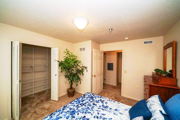 a bedroom with a large bed and a closet at Gull Prairie/Gull Run Apartments and Townhomes, Michigan