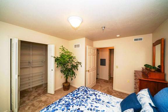a bedroom with a large bed and a closet at Gull Prairie/Gull Run Apartments and Townhomes, Kalamazoo, MI