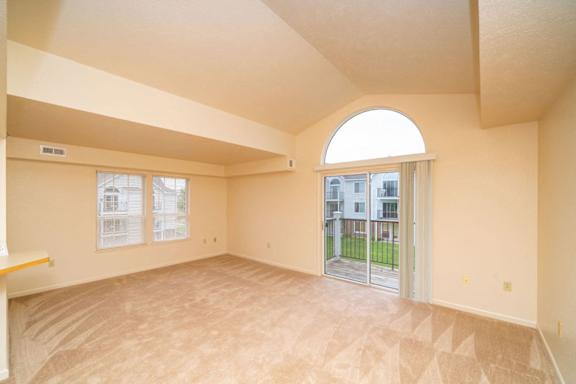 an empty living room with a door to a patio at Gull Prairie/Gull Run Apartments and Townhomes, Michigan, 49048