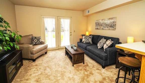 a living room with a couch and a table at Gull Prairie/Gull Run Apartments and Townhomes, Michigan, 49048