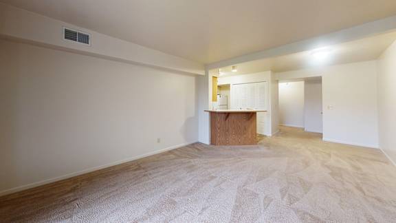 A living and dining room with a carpeted floor at Gull Prairie/Gull Run Apartments and Townhomes in Kalamazoo, MI
