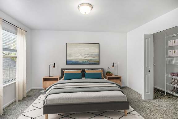 A bedroom with a large bed with a closet with wardrobe organizers at Gull Prairie/Gull Run Apartments and Townhomes, Kalamazoo, Michigan