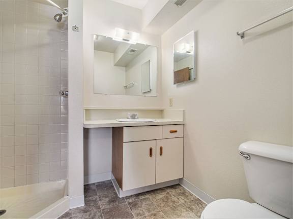 A white bathroom with a toilet, sink, and mirror.