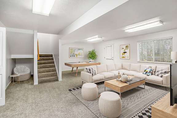 A spacious finished basement with a staircase and a window with blinds at Gull Prairie/Gull Run Apartments and Townhomes, Michigan, 49048