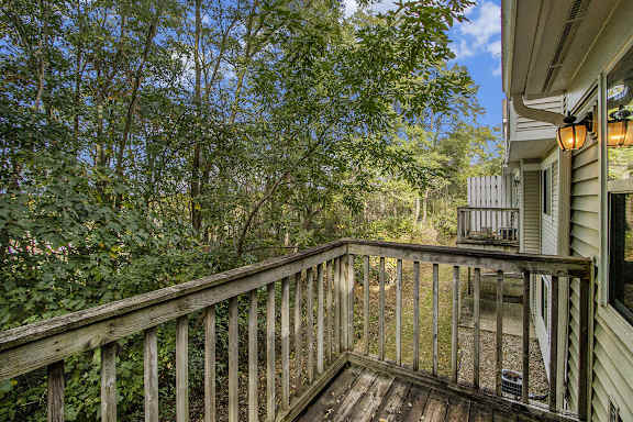 A wooden deck overlooks a wooded area at Gull Prairie/Gull Run Apartments and Townhomes, Michigan, 49048