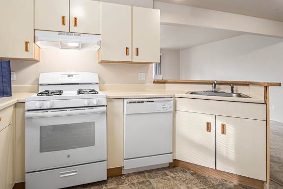 A kitchen with a white stove and white oven.