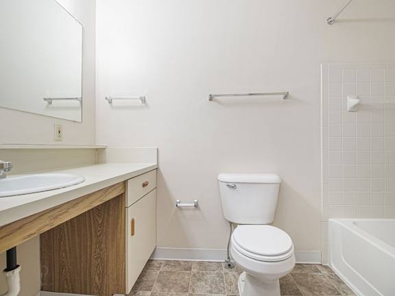 A white toilet sits in a bathroom next to a sink and a bathtub at Gull Prairie/Gull Run Apartments and Townhomes, Michigan, 49048