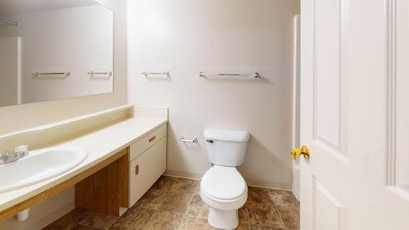 A bathroom with a large vanity, sink and a mirror at Gull Prairie/Gull Run Apartments and Townhomes, Michigan