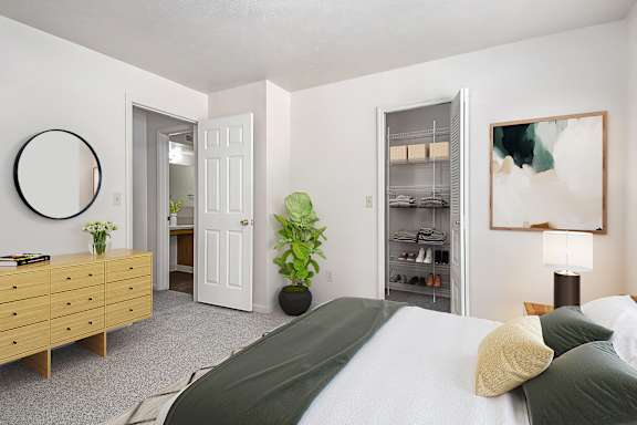 A bedroom with a bed, dresser, and a walk-in closet at Gull Prairie/Gull Run Apartments and Townhomes, Kalamazoo, 49048